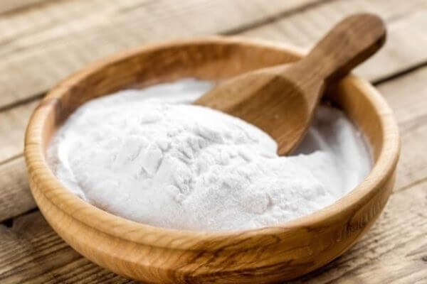 Chất ổn định thực phẩm là gì? Công dụng và các nhóm chất ổn định phổ biến 4 Bát gỗ đựng bột chất ổn định thực phẩm màu trắng mịn kèm xẻng xúc gỗ trên mặt bàn gỗ