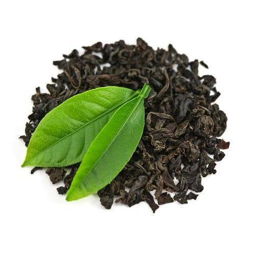 Bột Trà Đen Là Gì? Phân Biệt Với Trà Đen Dạng Lá 5 Đụn lá trà đen khô nguyên cánh xoăn đậm điểm xuyết hai búp lá trà xanh tươi trên nền trắng